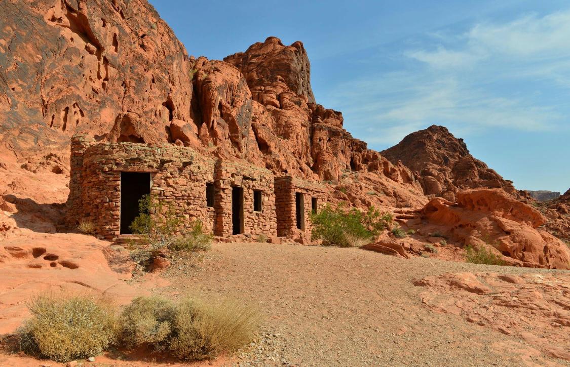 Stone ruins against red rock cliffs